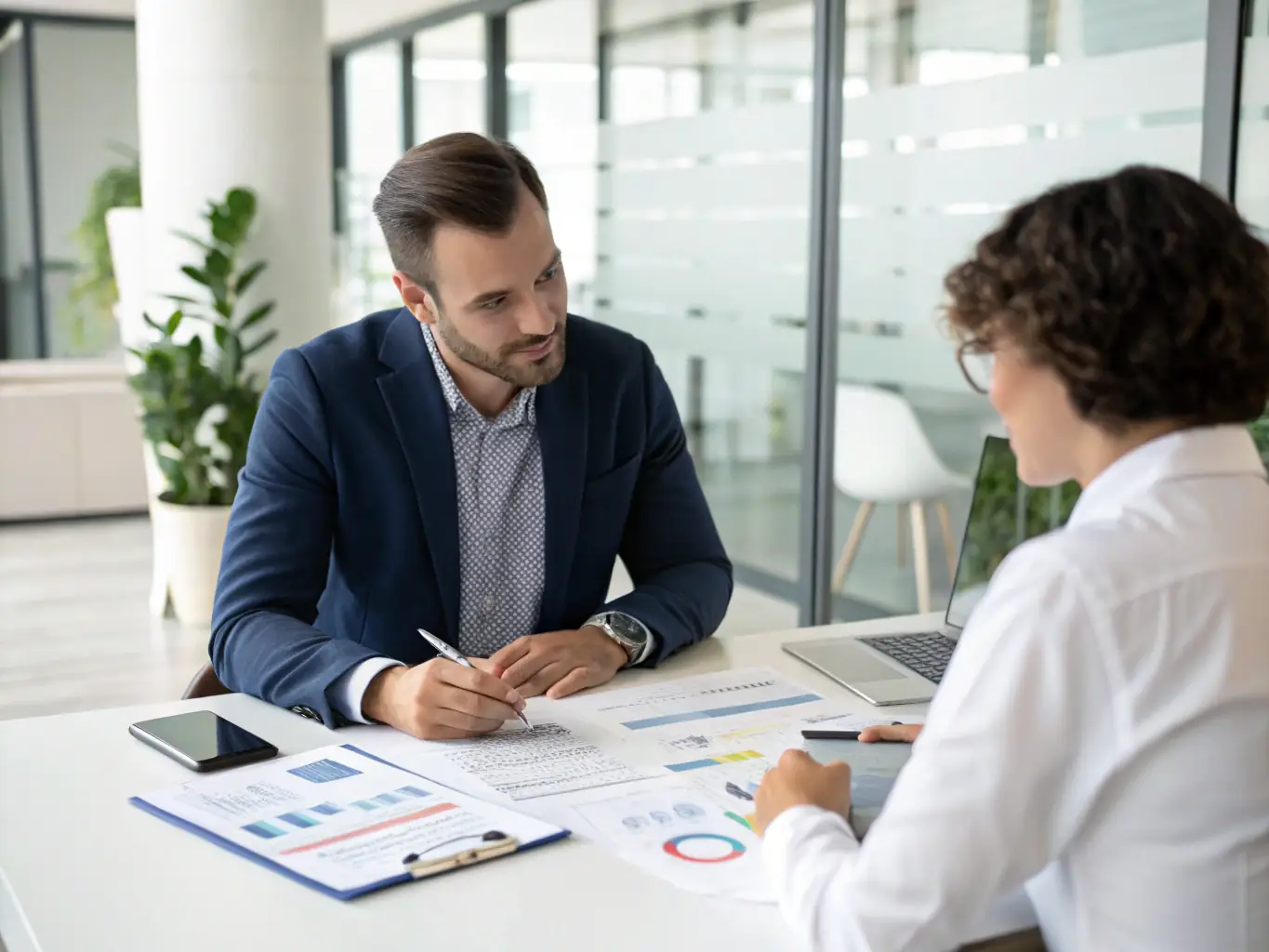 A financial consultant meeting with an Indian client, discussing investment options and financial planning.